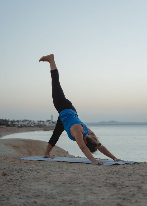 Woman in a calm yoga pose on a dusty rose background.